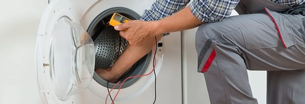 Dryer repair technician inspecting and repairing a clothes dryer in Cleveland, OH