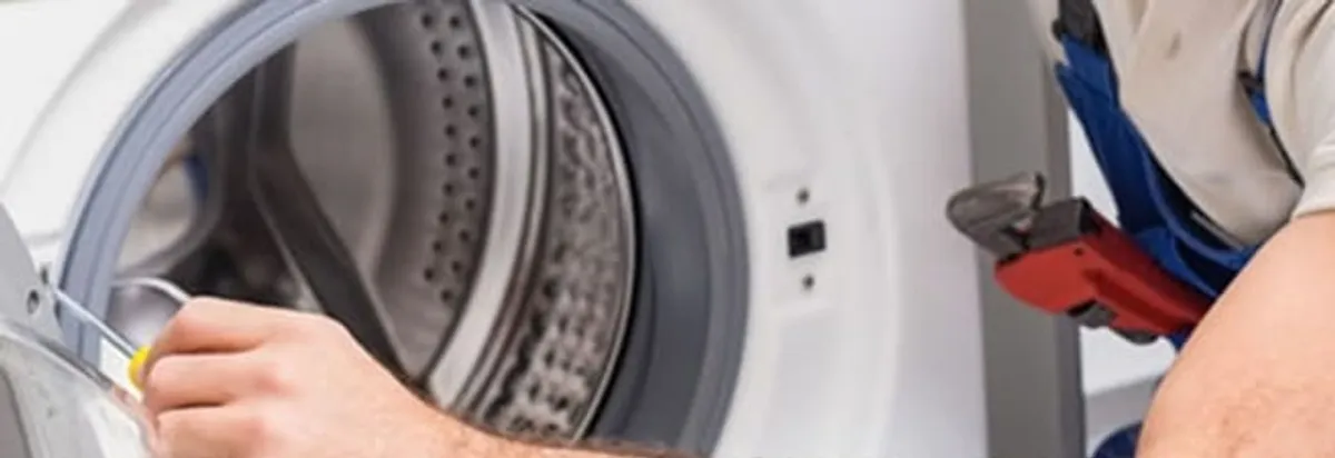 Appliance technician repairing a clothes dryer drum and internal parts in Cleveland, OH