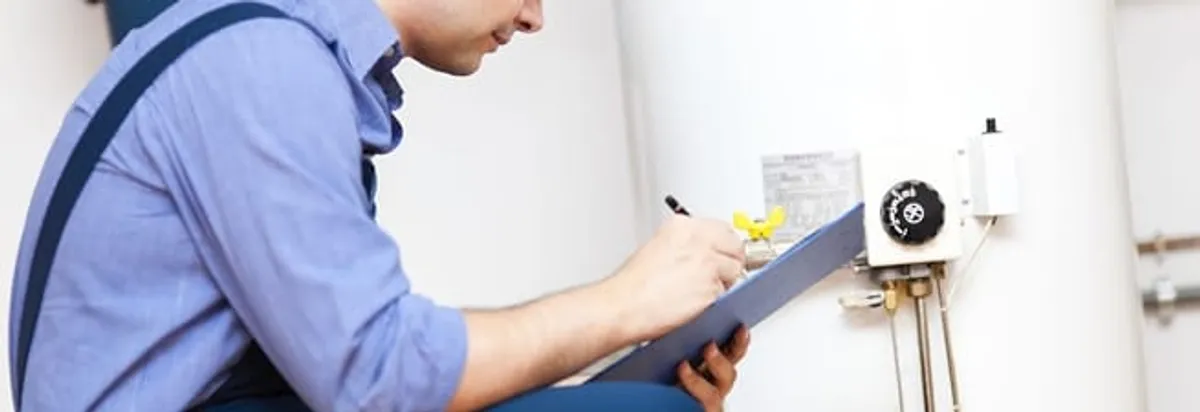 Water heater repair technician inspecting the unit and recording service notes in Cleveland, OH